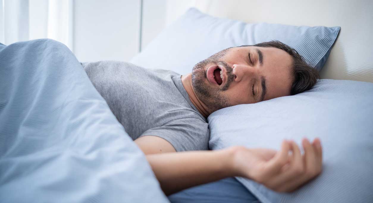 terapia CPAP na bezdech senny mężczyzna noszący maskę CPAP podczas snu z rurkami pod nosem w ciemności