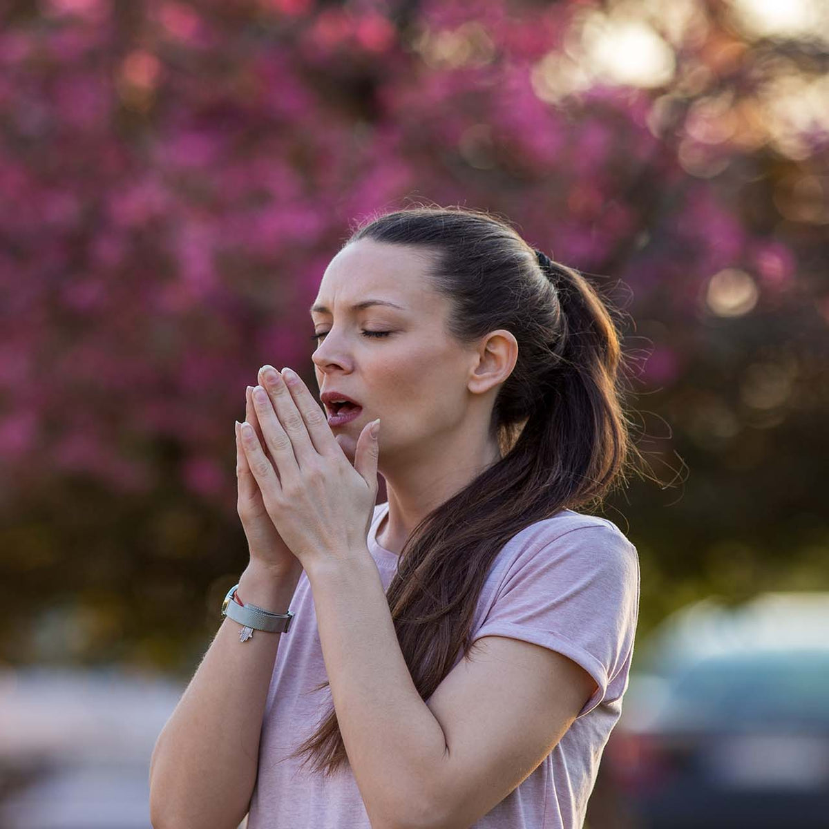 dziecko z alergią kaszlące obok pylących brzoz w parku miejskim